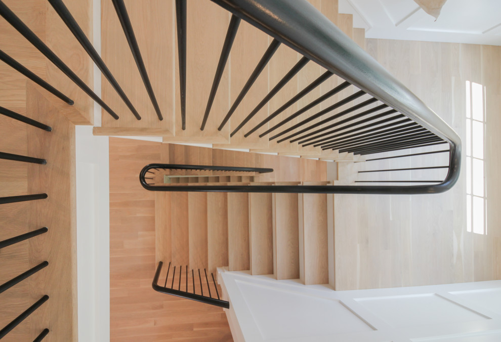 This is an example of a large modern wood u-shaped staircase in DC Metro with painted wood risers, mixed railing and decorative wall panelling.