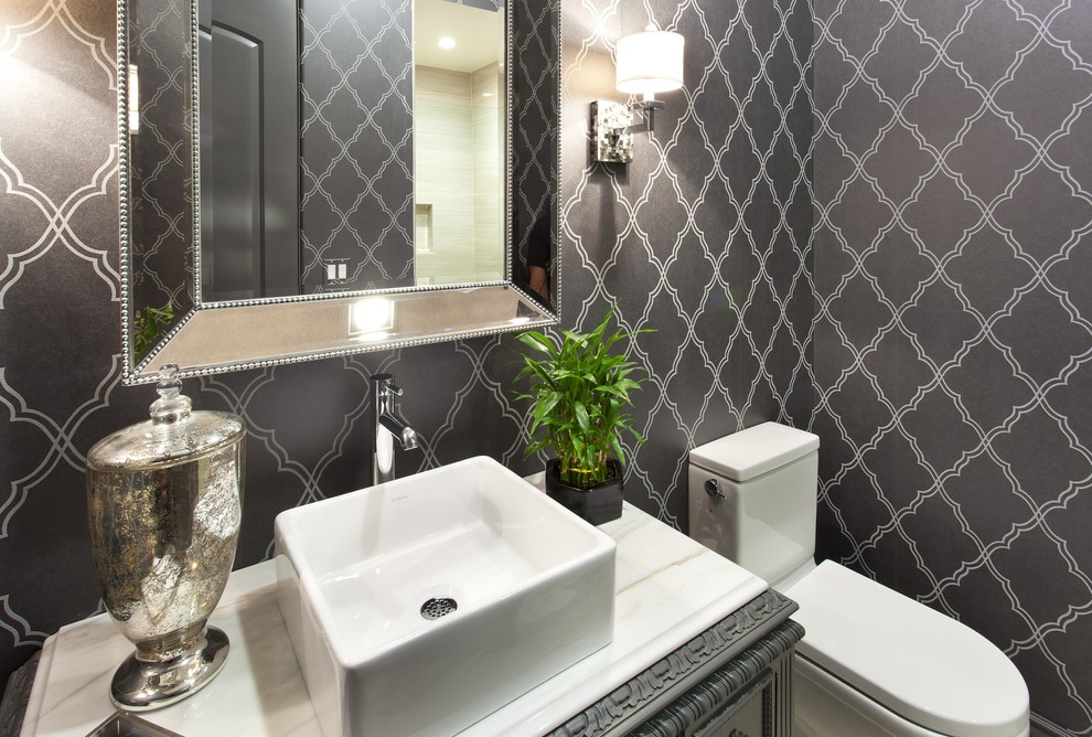 Photo of a mid-sized mediterranean powder room in San Francisco with black cabinets, a two-piece toilet, grey walls, a vessel sink and marble benchtops.