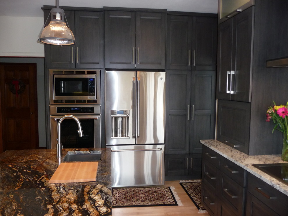 Inspiration for a large transitional u-shaped light wood floor eat-in kitchen remodel in Milwaukee with an undermount sink, flat-panel cabinets, gray cabinets, granite countertops, white backsplash, porcelain backsplash, stainless steel appliances and an island