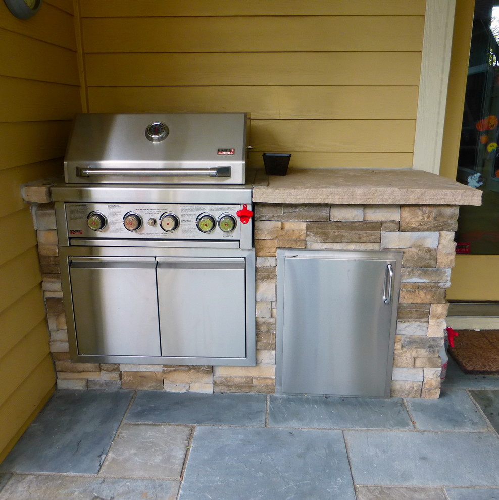 This is an example of a transitional backyard patio in Denver with natural stone pavers.