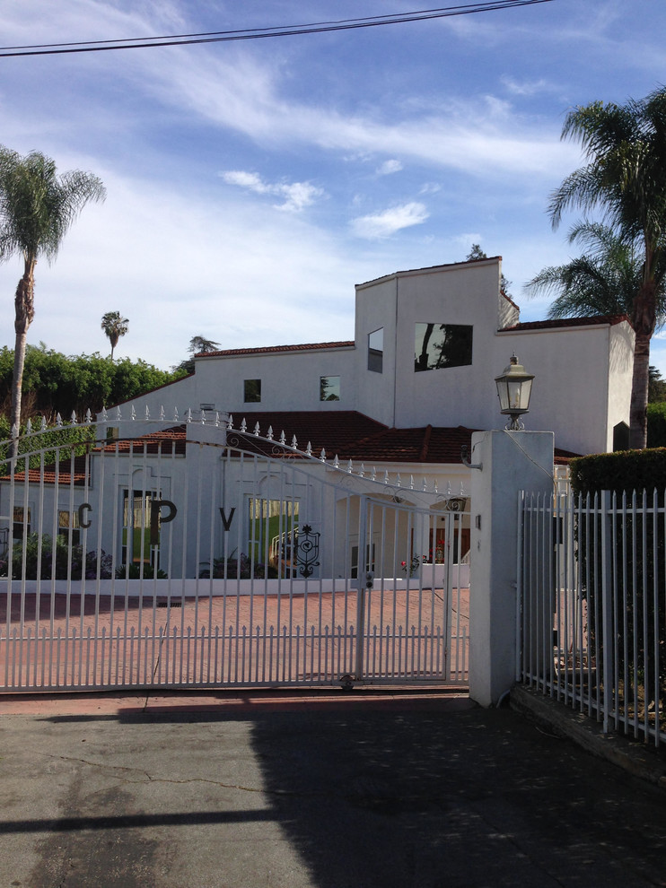 Large contemporary two-storey stucco white exterior in Los Angeles with a flat roof.