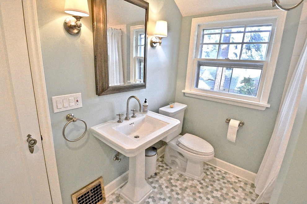 Photo of a small arts and crafts 3/4 bathroom with an alcove shower, a two-piece toilet, blue walls, porcelain floors, a pedestal sink, multi-coloured floor and a shower curtain.