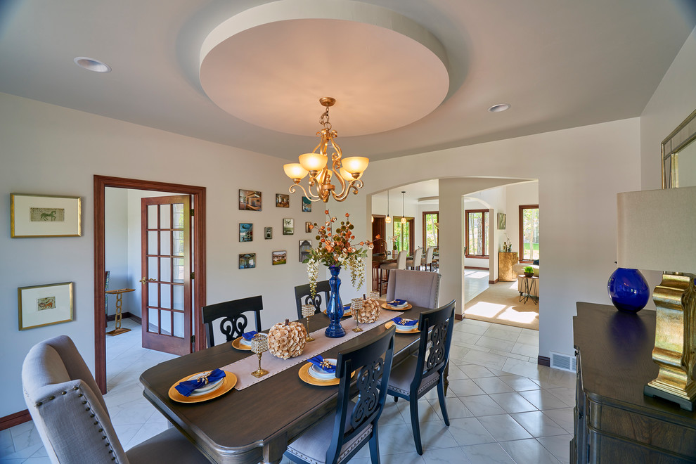 Example of a large transitional ceramic tile enclosed dining room design with white walls and no fireplace