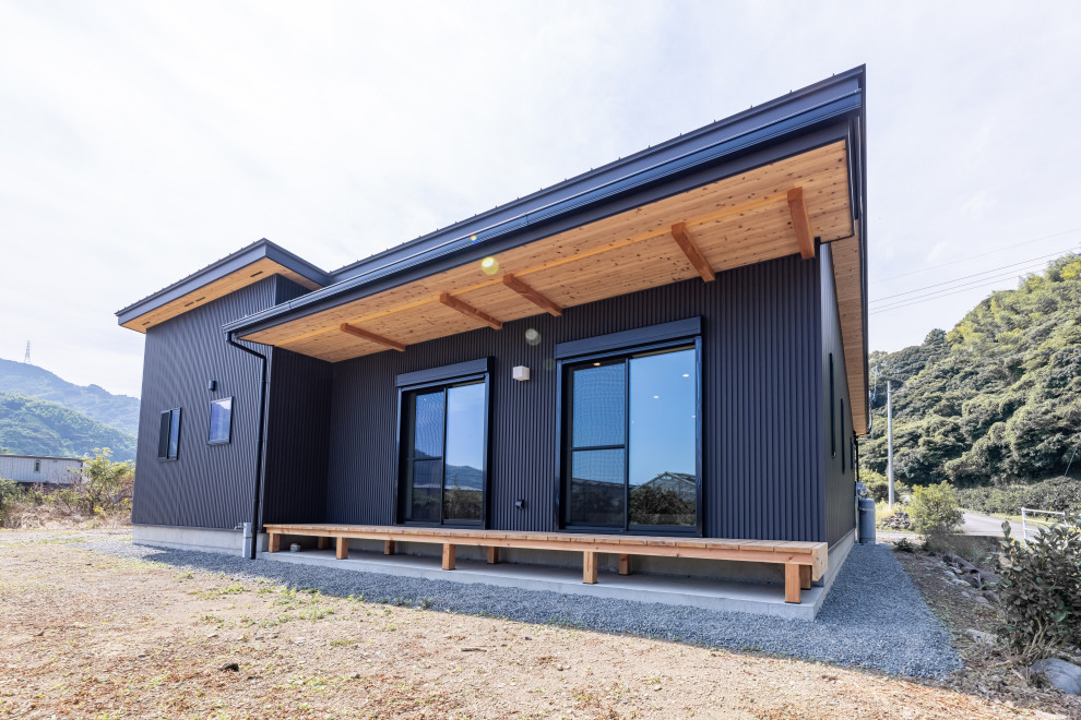 Inspiration pour une façade de maison métallique et noire de taille moyenne et de plain-pied avec un toit en appentis, un toit en métal et un toit noir.