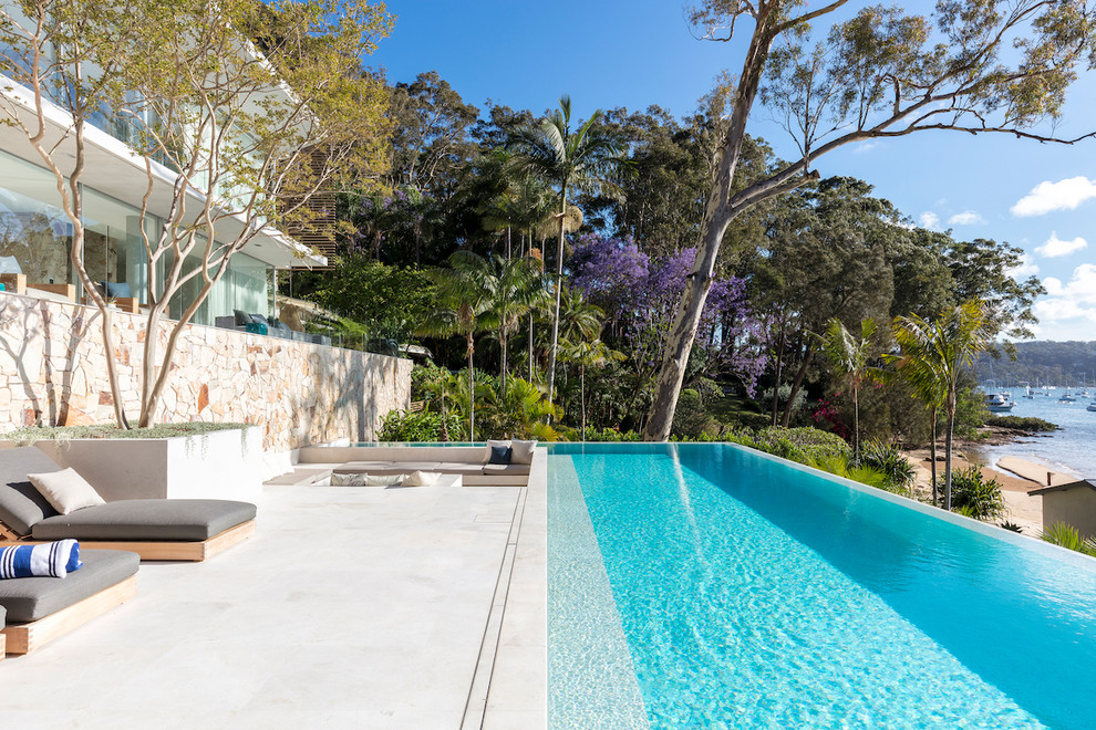 Photo of a beach style backyard rectangular infinity pool in Sydney.