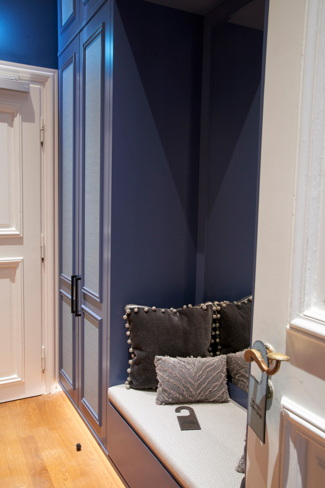 Réalisation d'un petit couloir avec un mur bleu, un sol en bois brun, un sol marron et boiseries.