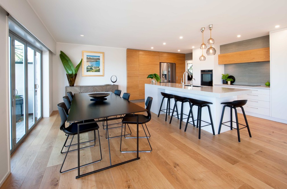 Photo of a mid-sized contemporary kitchen/dining combo in Auckland with medium hardwood floors and beige floor.