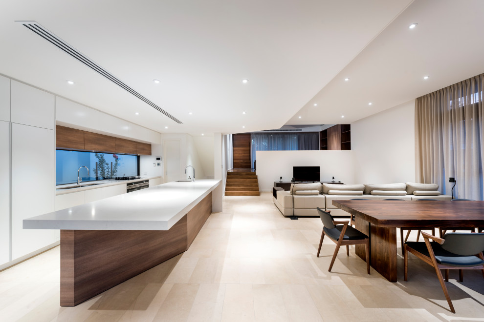 Large contemporary galley open plan kitchen in Perth with a double-bowl sink, flat-panel cabinets, white cabinets, window splashback, panelled appliances, with island, beige floor and white benchtop.