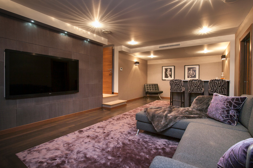 Photo of a contemporary home theatre in London with grey walls and brown floor.