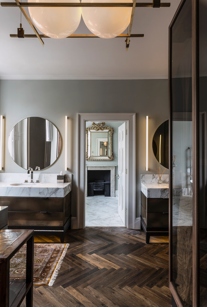 Photo of a traditional bathroom in London with flat-panel cabinets, brown cabinets, grey walls, dark hardwood floors, an undermount sink, brown floor and white benchtops.