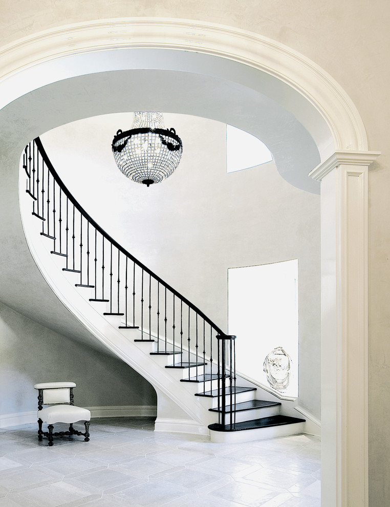 Inspiration for a large traditional wood curved staircase in New York with painted wood risers and metal railing.