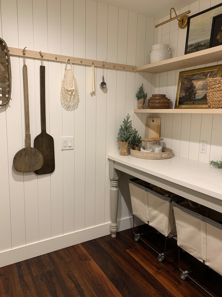 Inspiration for a mid-sized country dedicated laundry room with shaker cabinets, beige cabinets, quartz benchtops, white walls, vinyl floors, a stacked washer and dryer, brown floor and planked wall panelling.