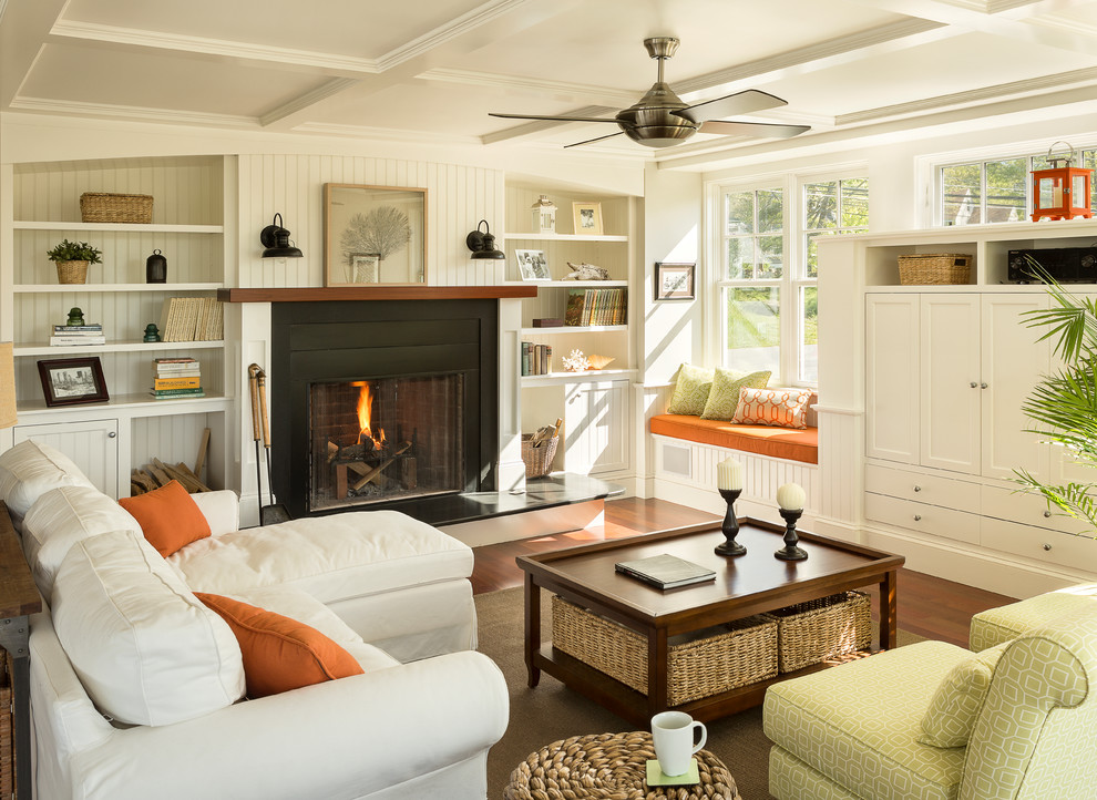 Inspiration for a mid-sized beach style family room in Portland Maine with white walls, medium hardwood floors, a standard fireplace and a concealed tv.