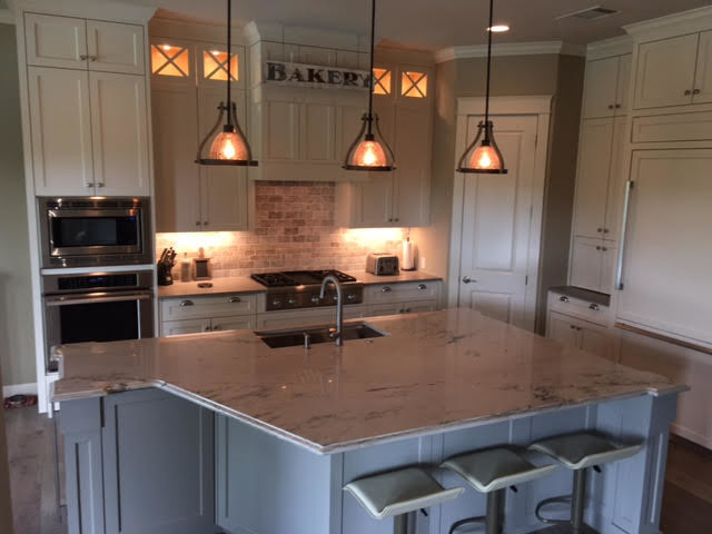 Mid-sized transitional l-shaped kitchen photo in Austin with an undermount sink, shaker cabinets, white cabinets, stainless steel appliances and an island