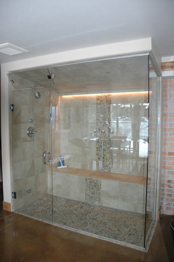 This is an example of a mid-sized traditional master bathroom in Other with beige tile, pebble tile, a hinged shower door, an alcove shower, brown walls, concrete floors and brown floor.