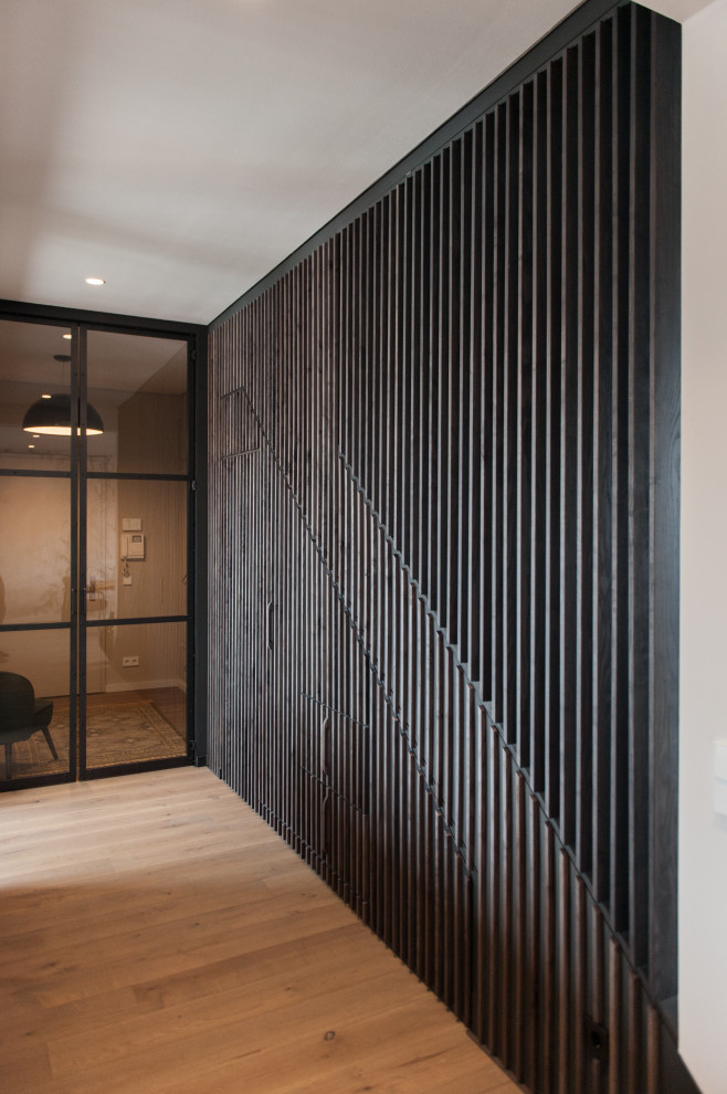 Свежая идея для дизайна: узкий коридор среднего размера в современном стиле с полом из ламината, коричневым полом и деревянными стенами - отличное фото интерьера