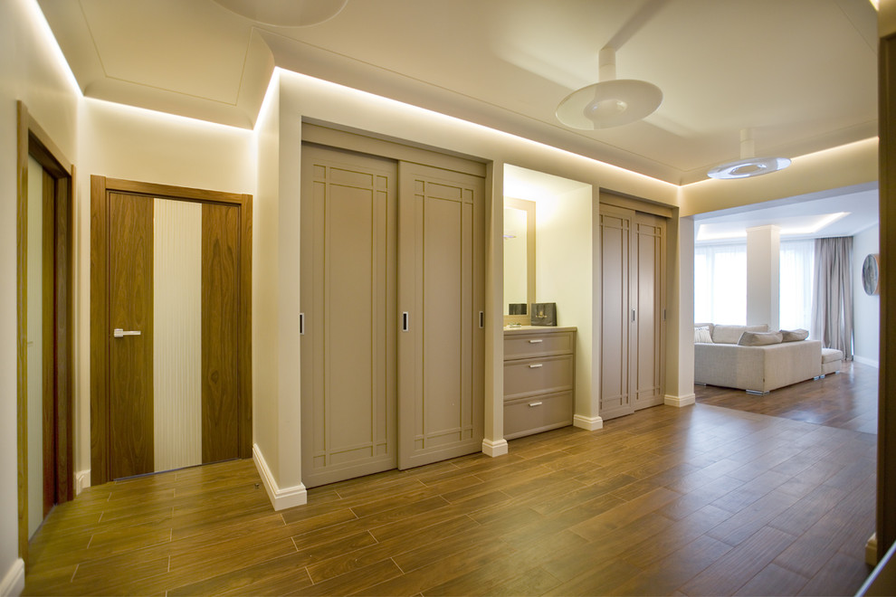This is an example of a mid-sized contemporary hallway in Saint Petersburg with beige walls, porcelain floors and brown floor.