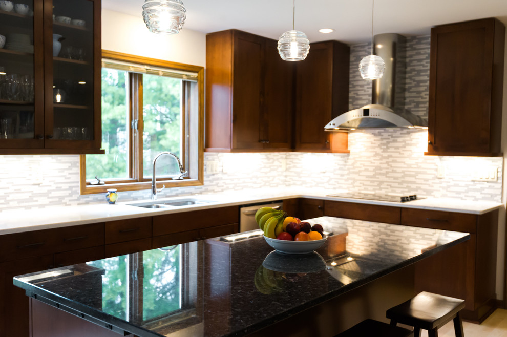 Inspiration for a large transitional l-shaped light wood floor eat-in kitchen remodel with an undermount sink, shaker cabinets, dark wood cabinets, quartz countertops, gray backsplash, matchstick tile backsplash, stainless steel appliances and an island