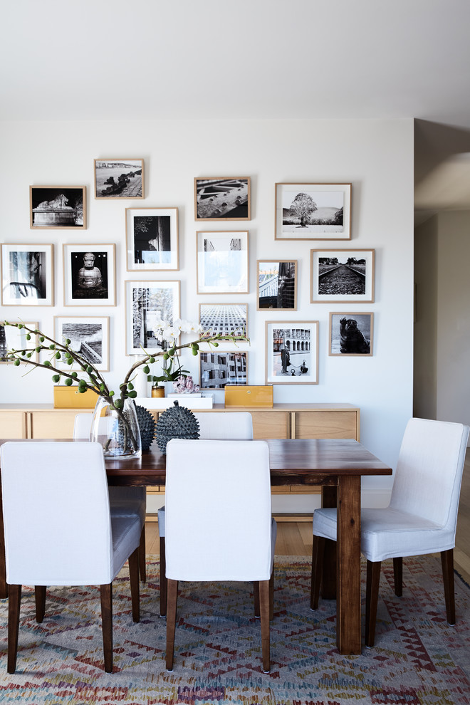 Inspiration for a transitional dining room in Melbourne with white walls, light hardwood floors and brown floor.