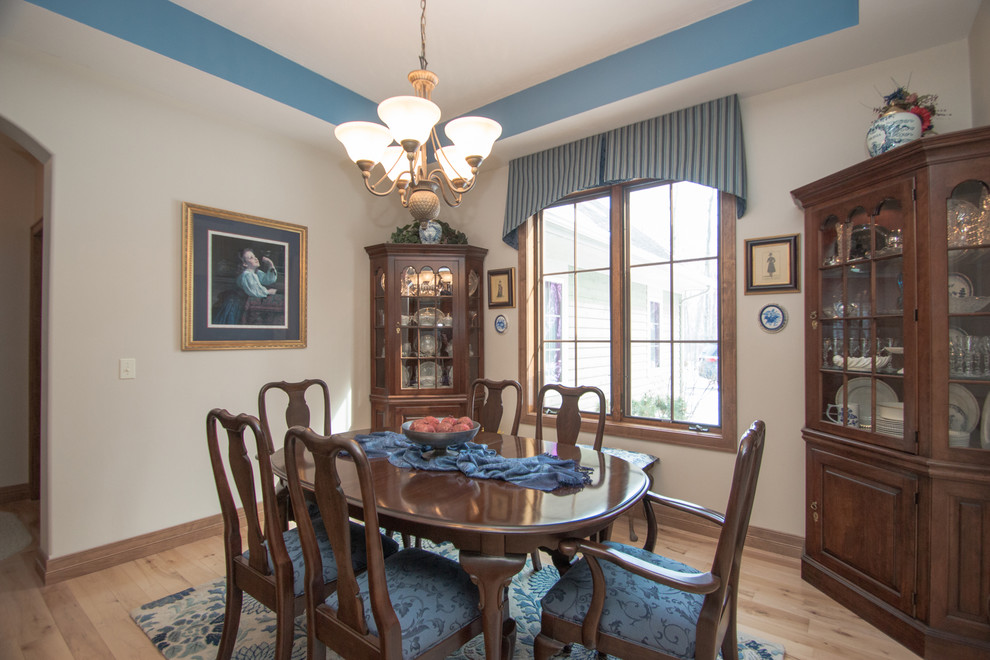 Mid-sized traditional separate dining room in Milwaukee with beige walls and light hardwood floors.