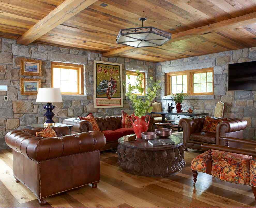 Country family room in New York with medium hardwood floors, multi-coloured walls, a wall-mounted tv and no fireplace.