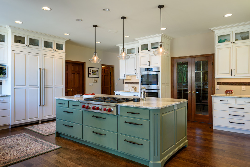 This is an example of a large traditional u-shaped eat-in kitchen in Seattle with a farmhouse sink, flat-panel cabinets, white cabinets, quartzite benchtops, beige splashback, porcelain splashback, stainless steel appliances, dark hardwood floors and with island.