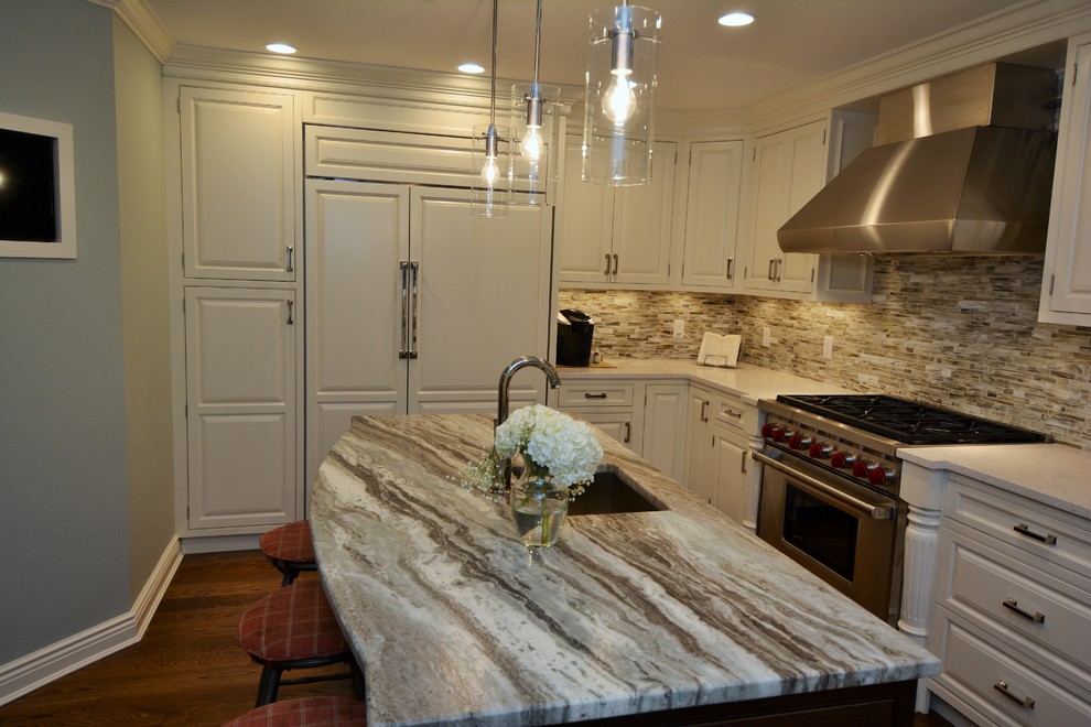 Kitchen - large transitional l-shaped dark wood floor kitchen idea in Boston with raised-panel cabinets, white cabinets, granite countertops, multicolored backsplash, ceramic backsplash, stainless steel appliances, an island and a farmhouse sink