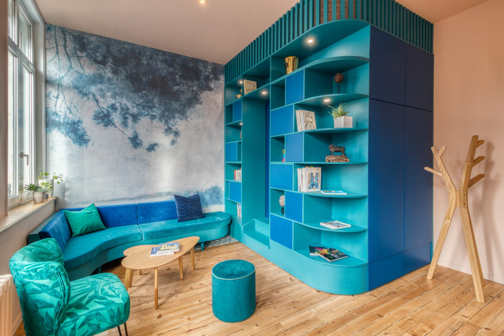 Идея дизайна: гостиная комната среднего размера:: освещение в стиле неоклассика (современная классика) с с книжными шкафами и полками, розовыми стенами, светлым паркетным полом и обоями на стенах