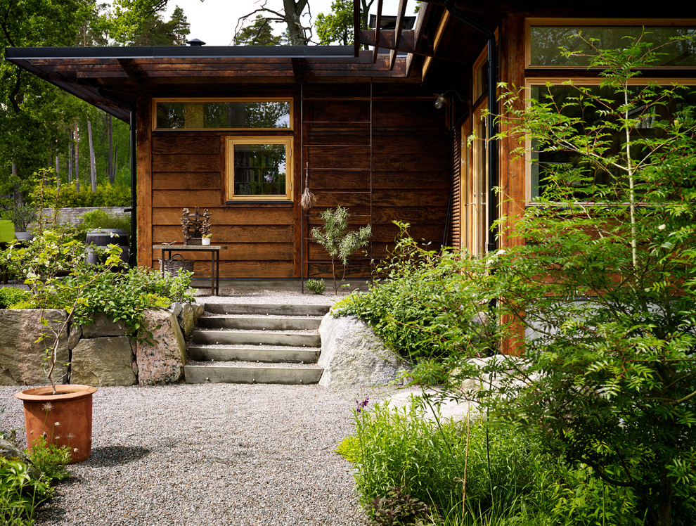 Inspiration for an asian front yard patio in Stockholm with gravel and a roof extension.