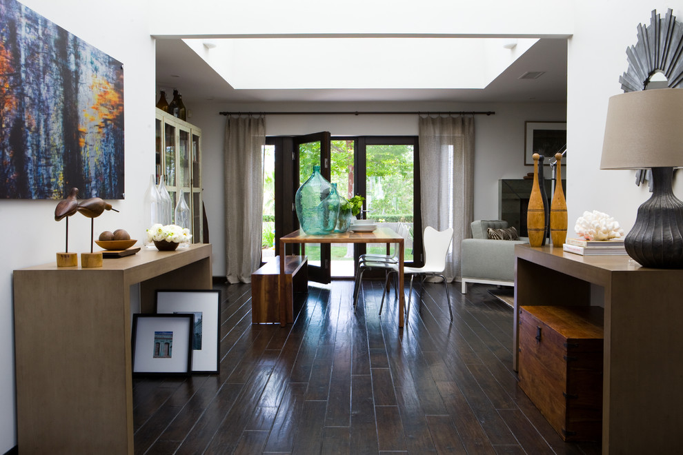 This is an example of a mid-sized eclectic foyer in Los Angeles with white walls and dark hardwood floors.