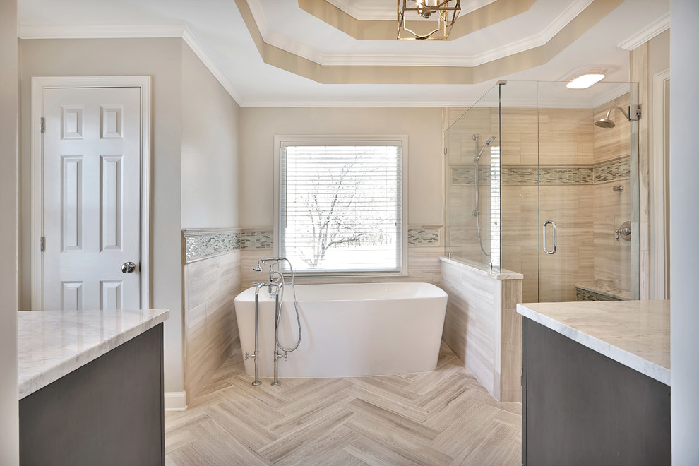 Design ideas for a large traditional master bathroom in Atlanta with recessed-panel cabinets, grey cabinets, a freestanding tub, an alcove shower, beige tile, porcelain tile, beige walls, porcelain floors, an undermount sink, marble benchtops, beige floor and a hinged shower door.