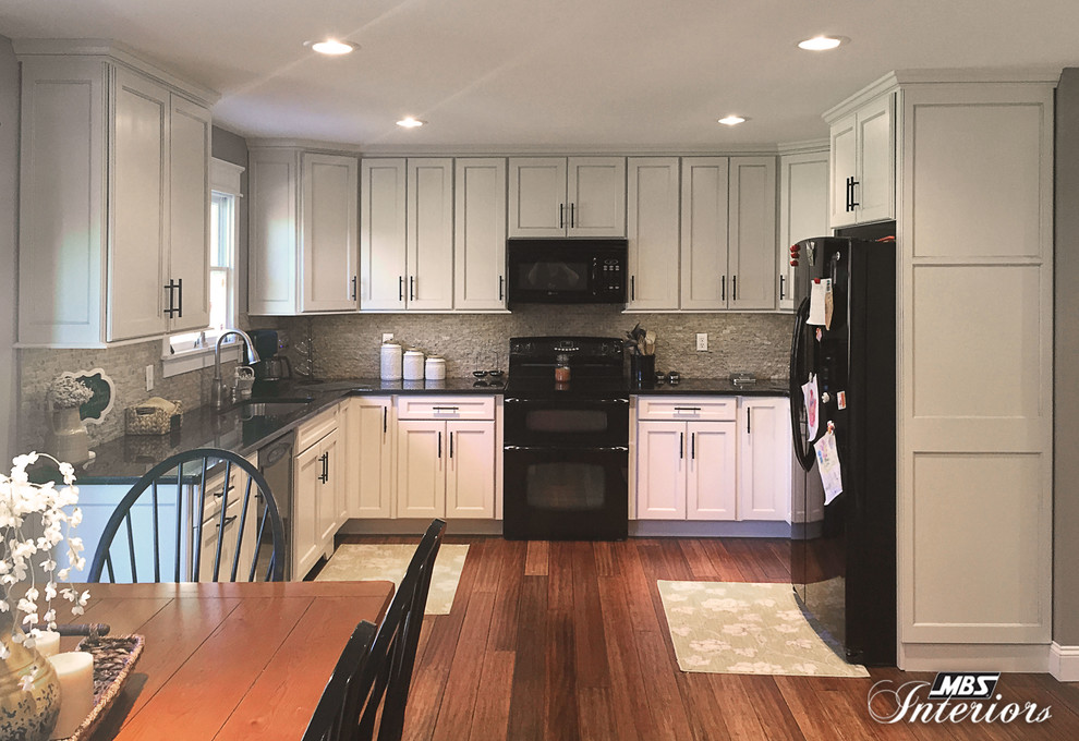 Example of a mid-sized transitional u-shaped medium tone wood floor eat-in kitchen design in Cincinnati with an undermount sink, flat-panel cabinets, white cabinets, granite countertops, gray backsplash, stone tile backsplash, black appliances and no island