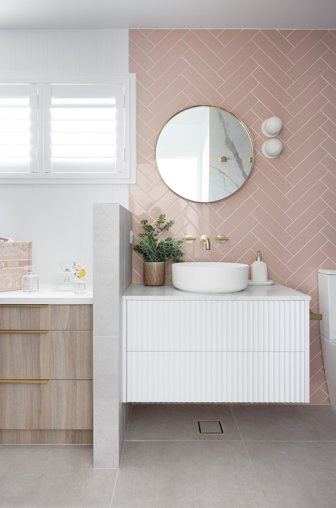 Cette photo montre une salle de bain tendance avec un placard à porte plane, des portes de placard blanches, un carrelage rose, un mur blanc, une vasque, un sol gris, un plan de toilette blanc, meuble simple vasque et meuble-lavabo suspendu.