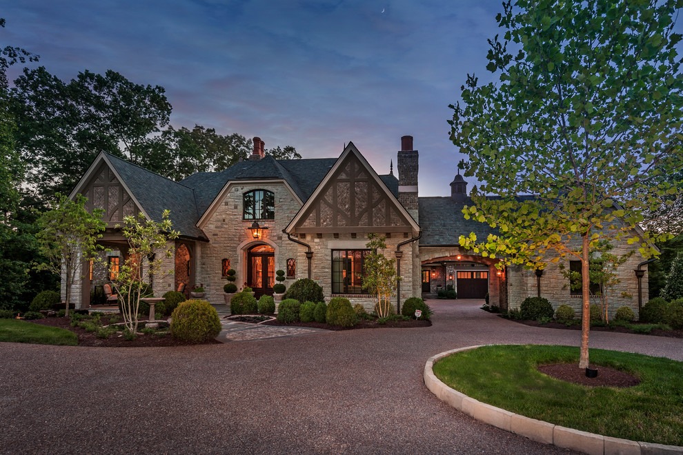 Large elegant gray two-story stone house exterior photo with a shingle roof