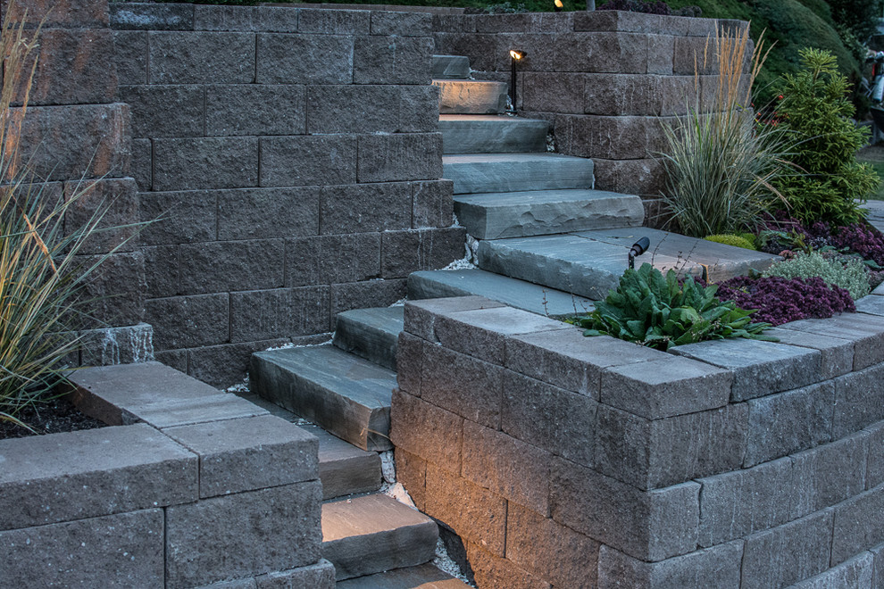 Design ideas for a beach style sloped full sun garden in Seattle with a retaining wall and concrete pavers.