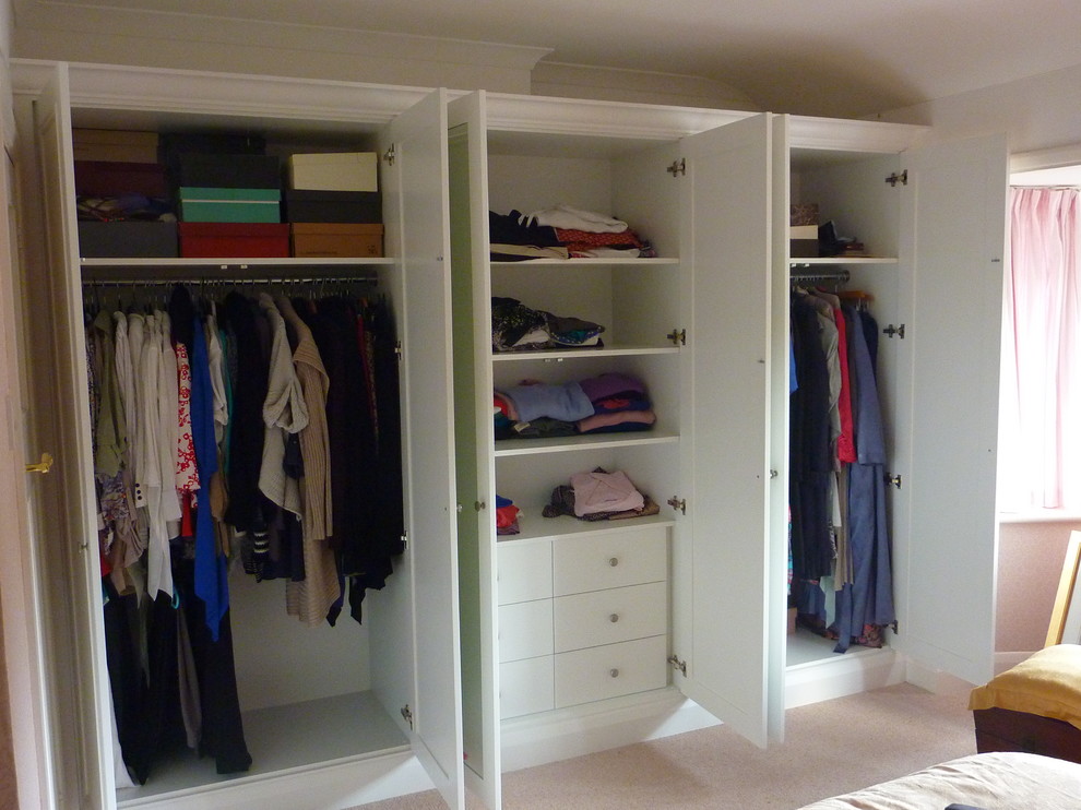 This is an example of a mid-sized contemporary storage and wardrobe in Surrey with dark hardwood floors.
