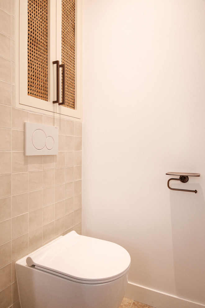 Foto di un piccolo bagno di servizio con ante beige, WC sospeso, piastrelle beige, piastrelle di vetro, pareti bianche, pavimento in travertino, pavimento beige e mobile bagno incassato