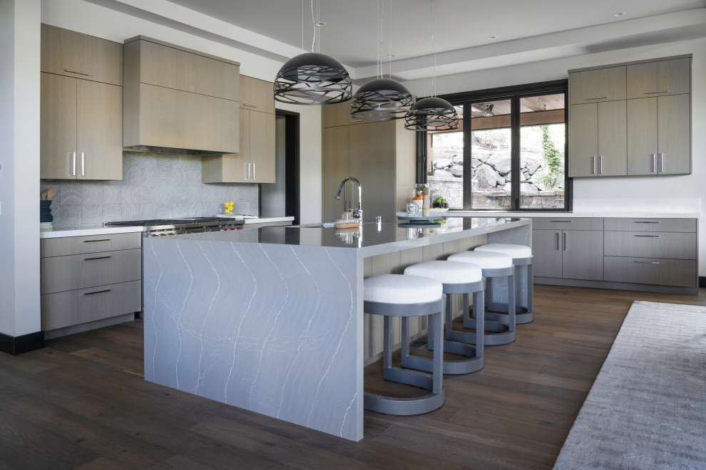 Inspiration for a large contemporary l-shaped eat-in kitchen in Sacramento with a single-bowl sink, flat-panel cabinets, quartz benchtops, ceramic splashback, panelled appliances, medium hardwood floors, with island, brown floor, grey benchtop, grey cabinets, grey splashback and recessed.