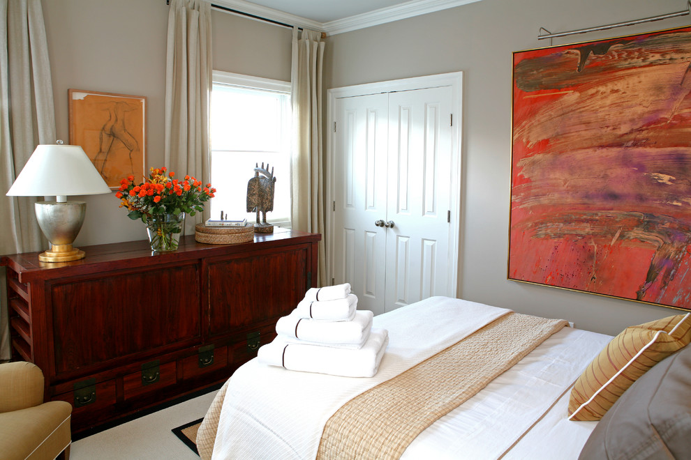 Photo of a mid-sized transitional guest bedroom in New York with grey walls and medium hardwood floors.