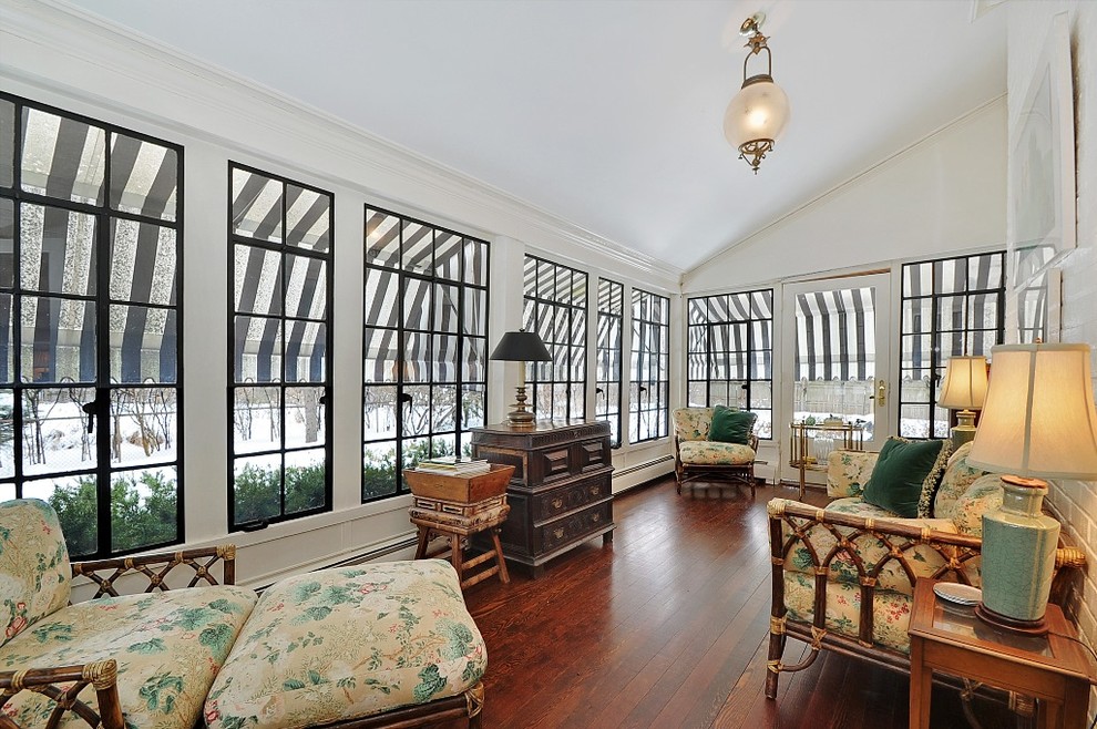 This is an example of a traditional sunroom in Chicago with dark hardwood floors.