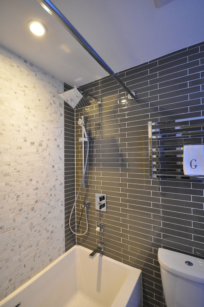 This is an example of a small modern 3/4 bathroom in Vancouver with an integrated sink, flat-panel cabinets, white cabinets, glass benchtops, a hot tub, a shower/bathtub combo, a two-piece toilet, brown tile, glass tile and porcelain floors.