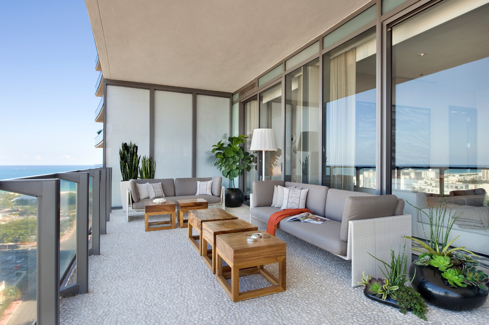 This is an example of a contemporary deck in Miami with a roof extension.