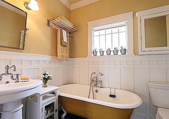 This is an example of a mid-sized traditional master bathroom in Houston with white cabinets, a claw-foot tub, a two-piece toilet, yellow walls and a pedestal sink.