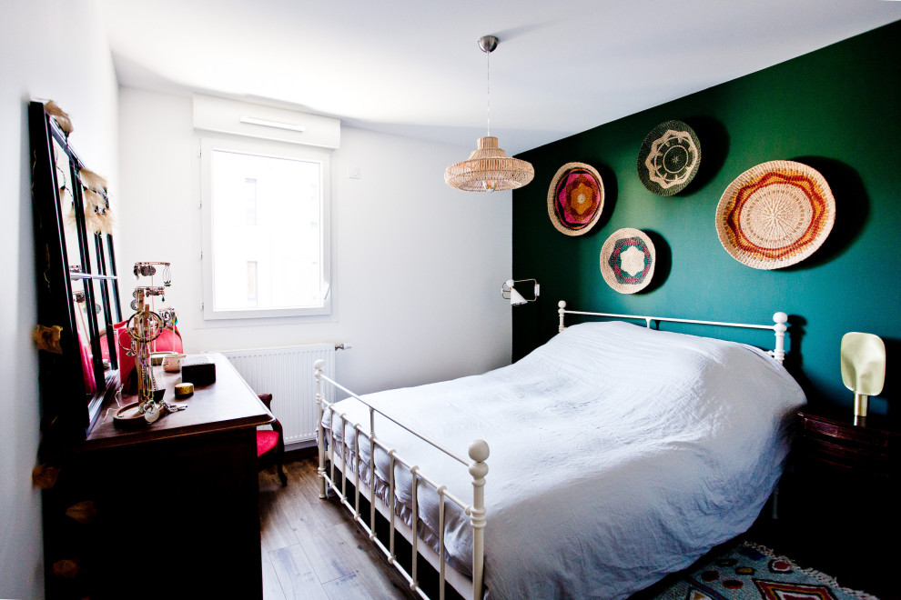 Ejemplo de habitación de invitados ecléctica grande sin chimenea con paredes verdes, suelo de madera en tonos medios y suelo marrón