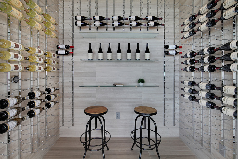 This is an example of a contemporary wine cellar in Orange County with storage racks and grey floor.