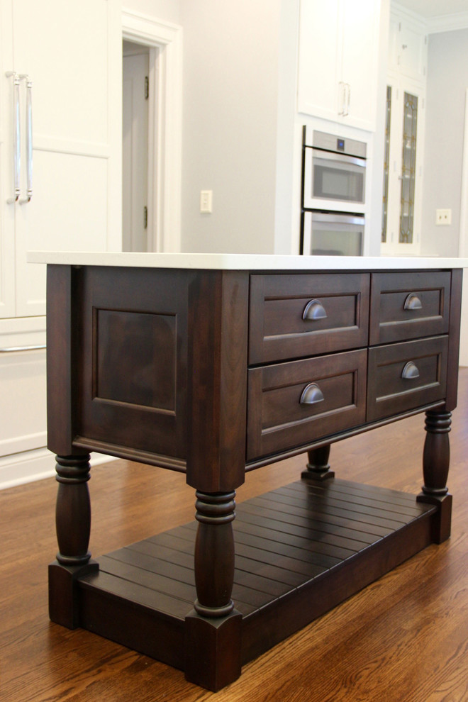 Eat-in kitchen - mid-sized transitional u-shaped medium tone wood floor and brown floor eat-in kitchen idea with a farmhouse sink, shaker cabinets, white cabinets, quartz countertops, white backsplash, subway tile backsplash, white appliances and an island