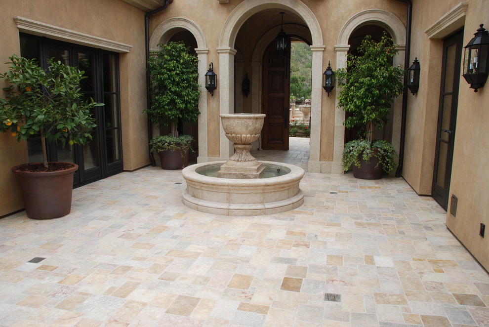 Large mediterranean backyard partial sun garden in New York with a water feature and natural stone pavers.