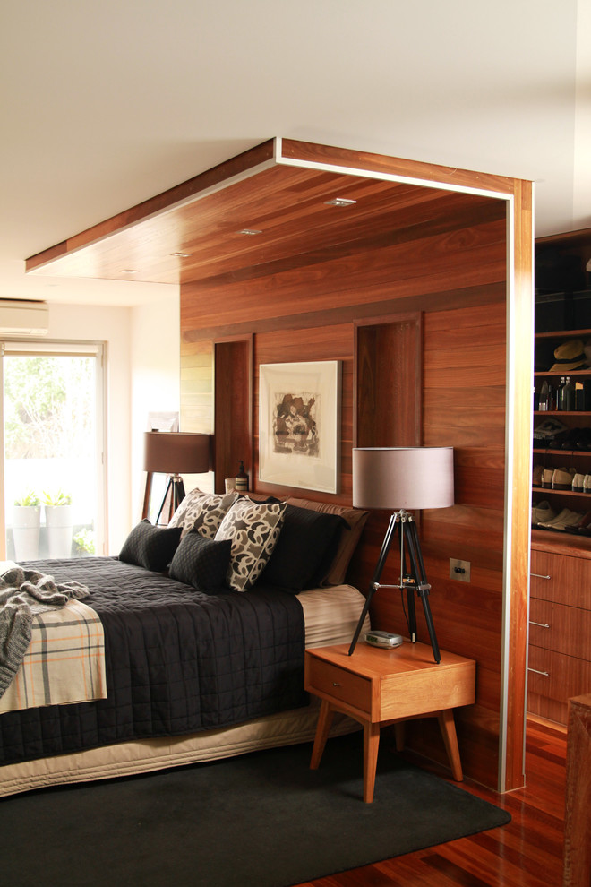 Large eclectic master bedroom in Other with beige walls and dark hardwood floors.