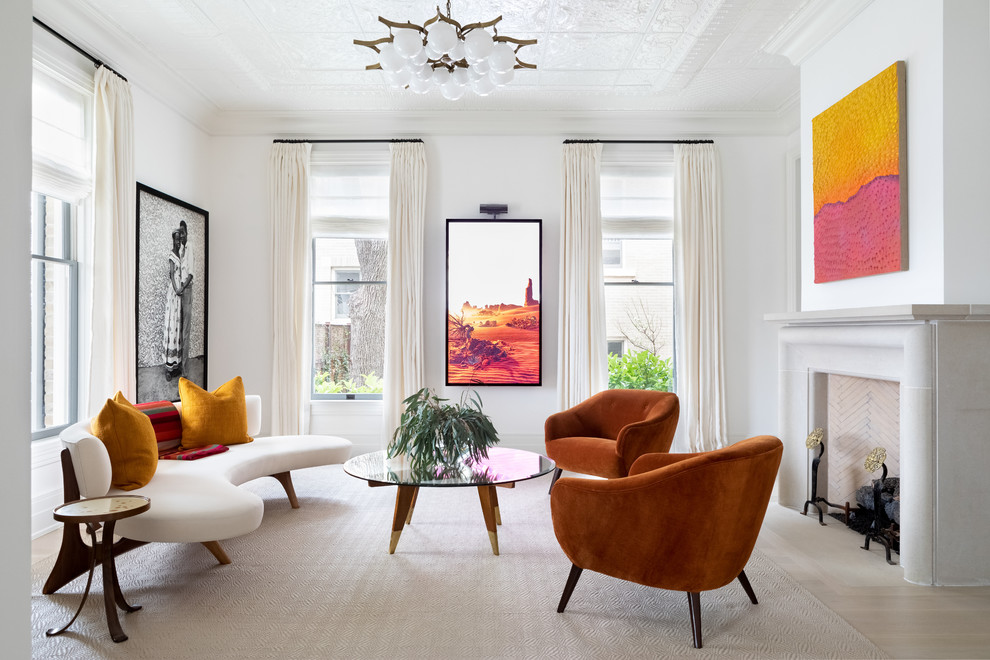 Large transitional formal living room in Austin with light hardwood floors, white walls and a standard fireplace.