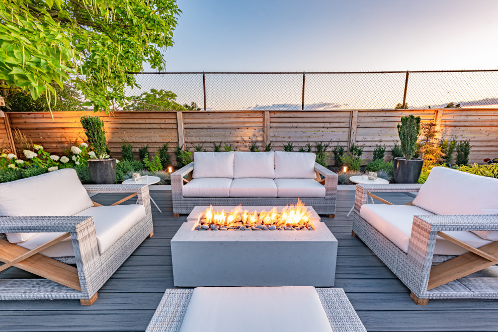 Mid-sized contemporary backyard deck in Toronto with a pergola.